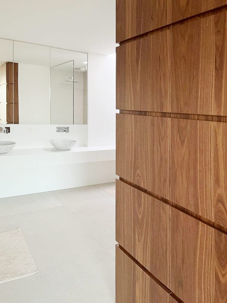 Badkamer met dubbele lavabo en houten wandkast